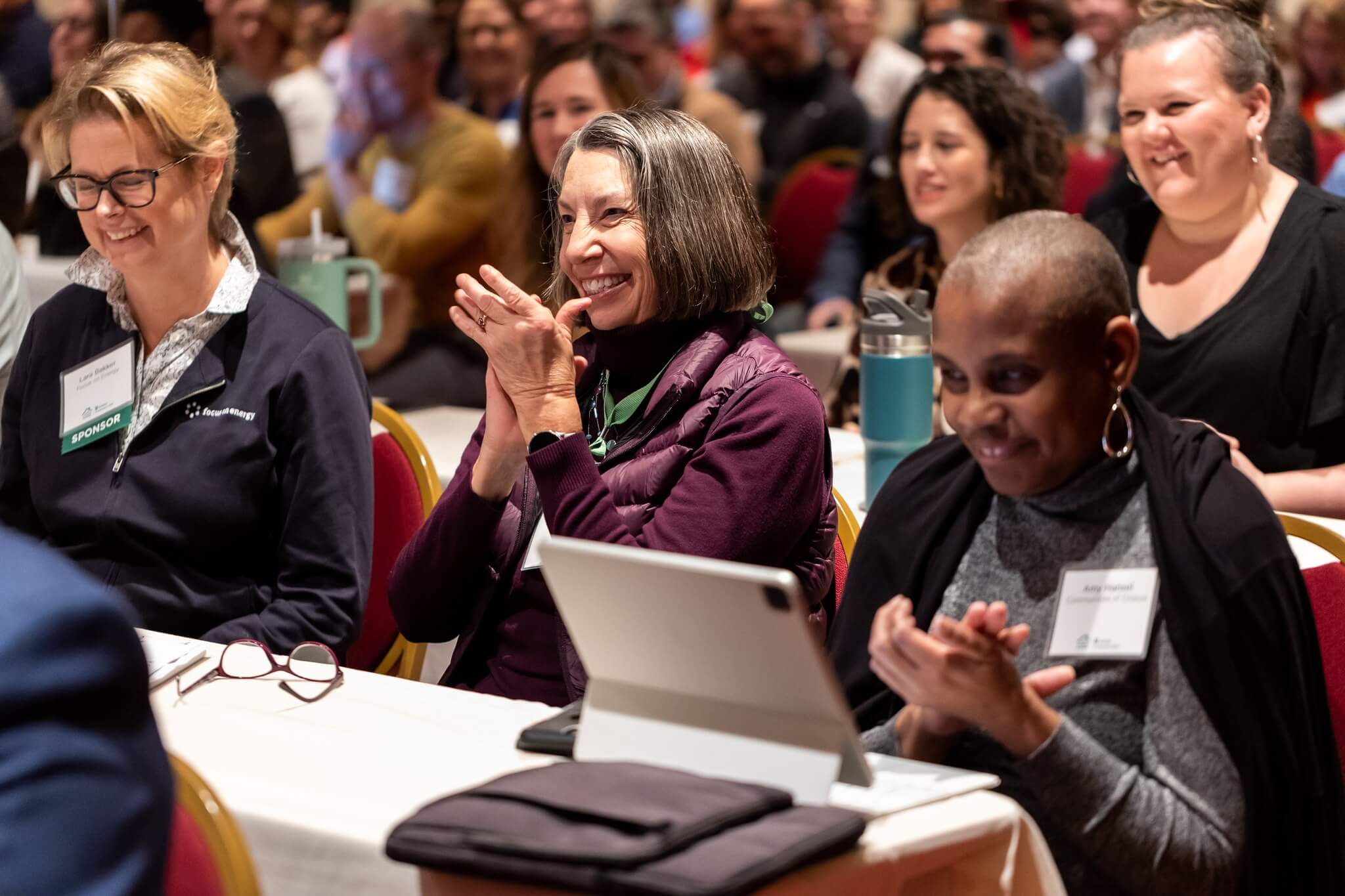 photo of attendees clapping and smiling in audience at WHEDA Conference